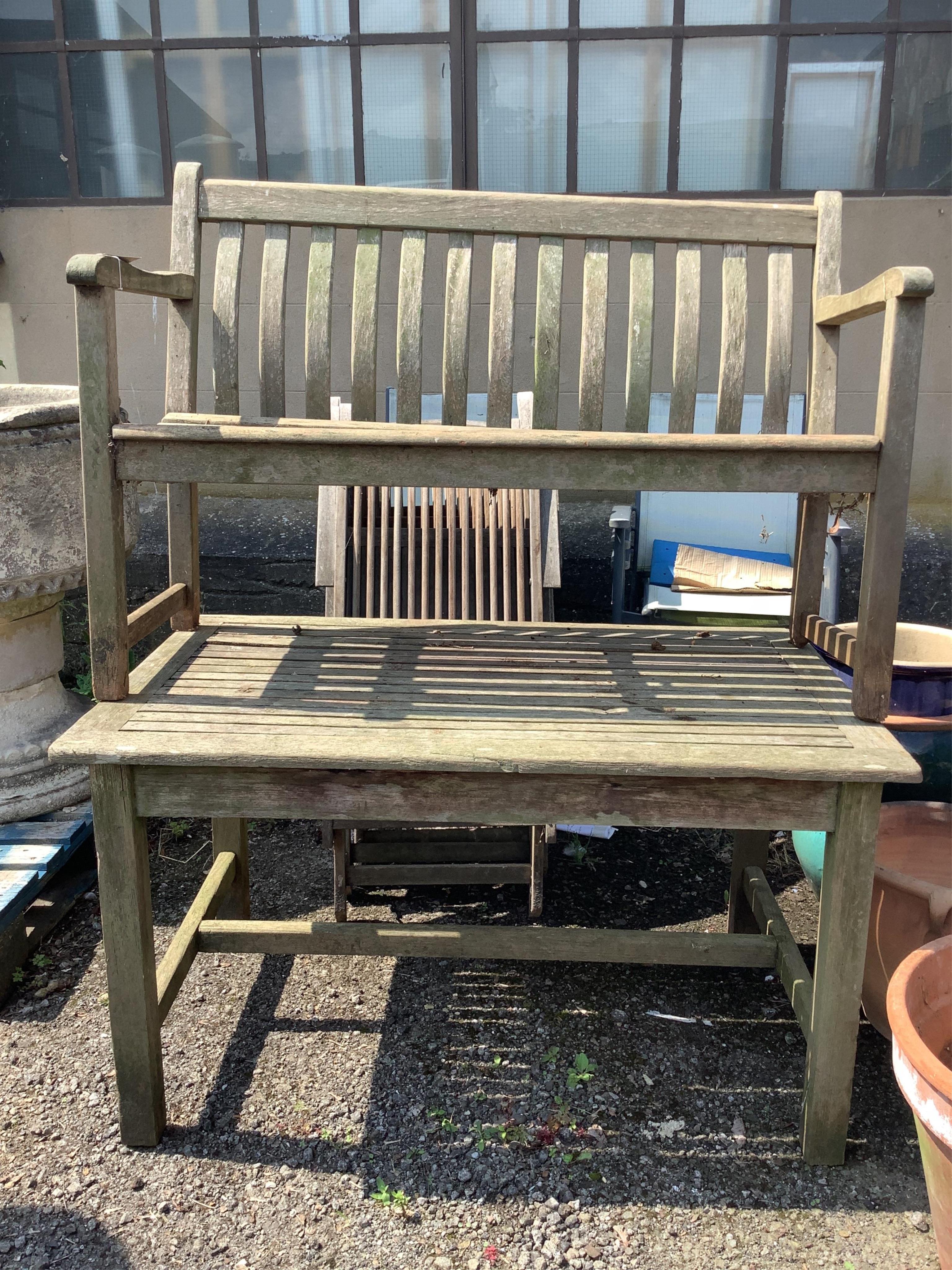 A set of four weathered teak folding garden armchairs, width 52cm, height 98cm, together with a rectangular garden table and bench. Condition - poor to fair